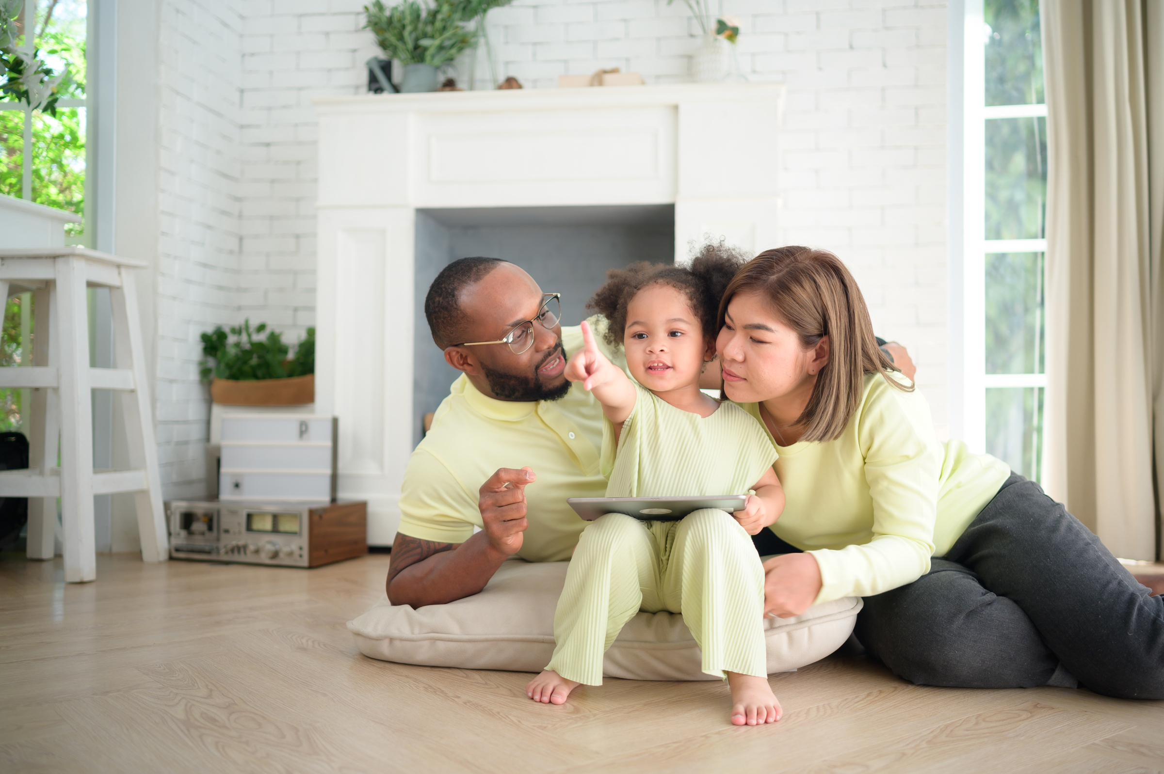 A small child playing with parents after discussing mortgage options with a loan officer.